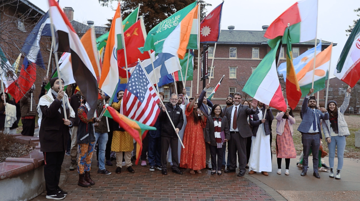 A group of international students, scholars and staff members wave their flags at the flag parade in SIUC Carbondale. 